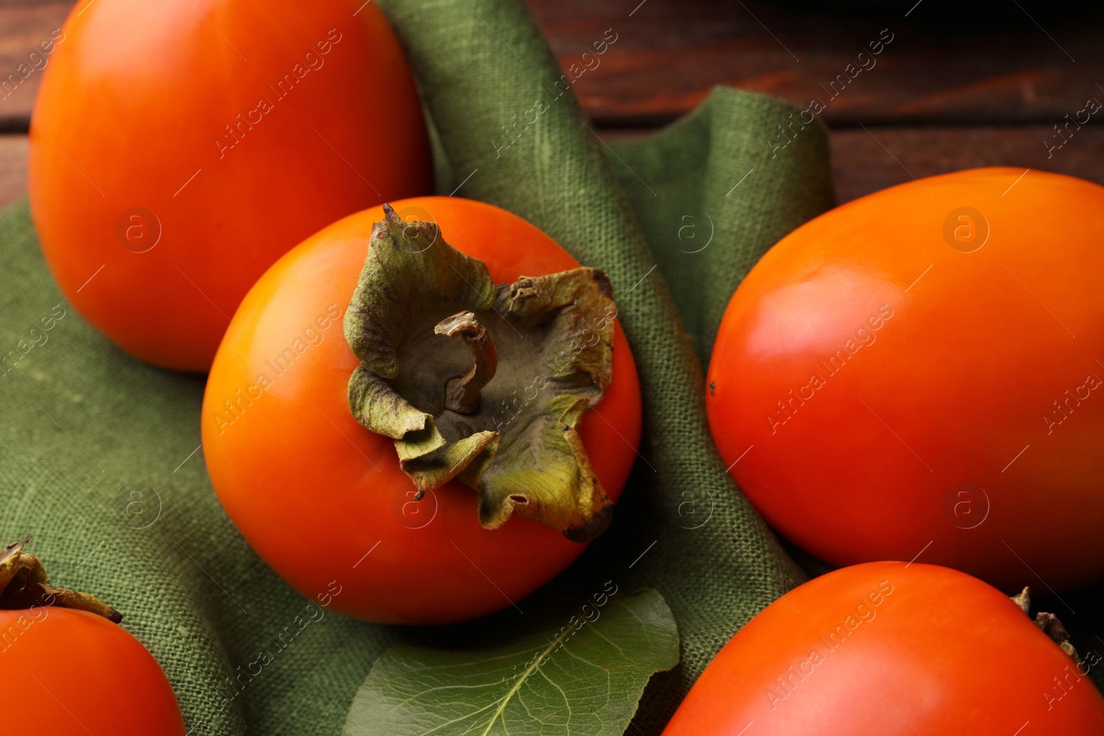 Photo of Delicious ripe juicy persimmons on wooden table