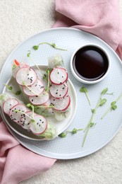 Photo of Delicious spring rolls, microgreens and soy sauce on light grey table, top view