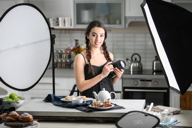 Photo of Young woman with professional camera in photo studio