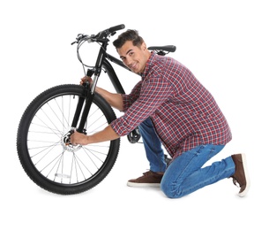 Handsome young man with modern bicycle on white background