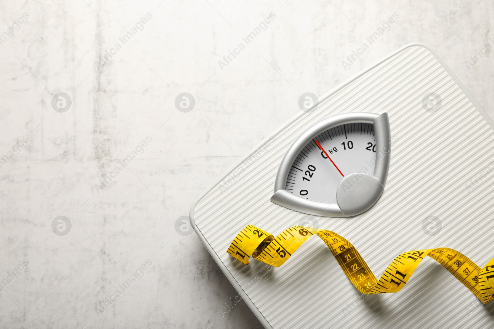 Photo of Weigh scales and measuring tape on white textured background, top view with space for text. Overweight concept