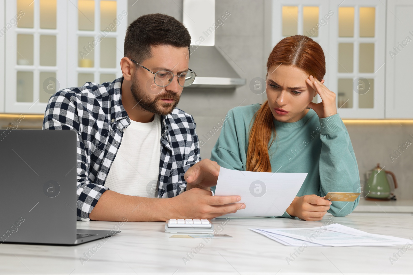 Photo of Couple with credit card using laptop for paying taxes online at home