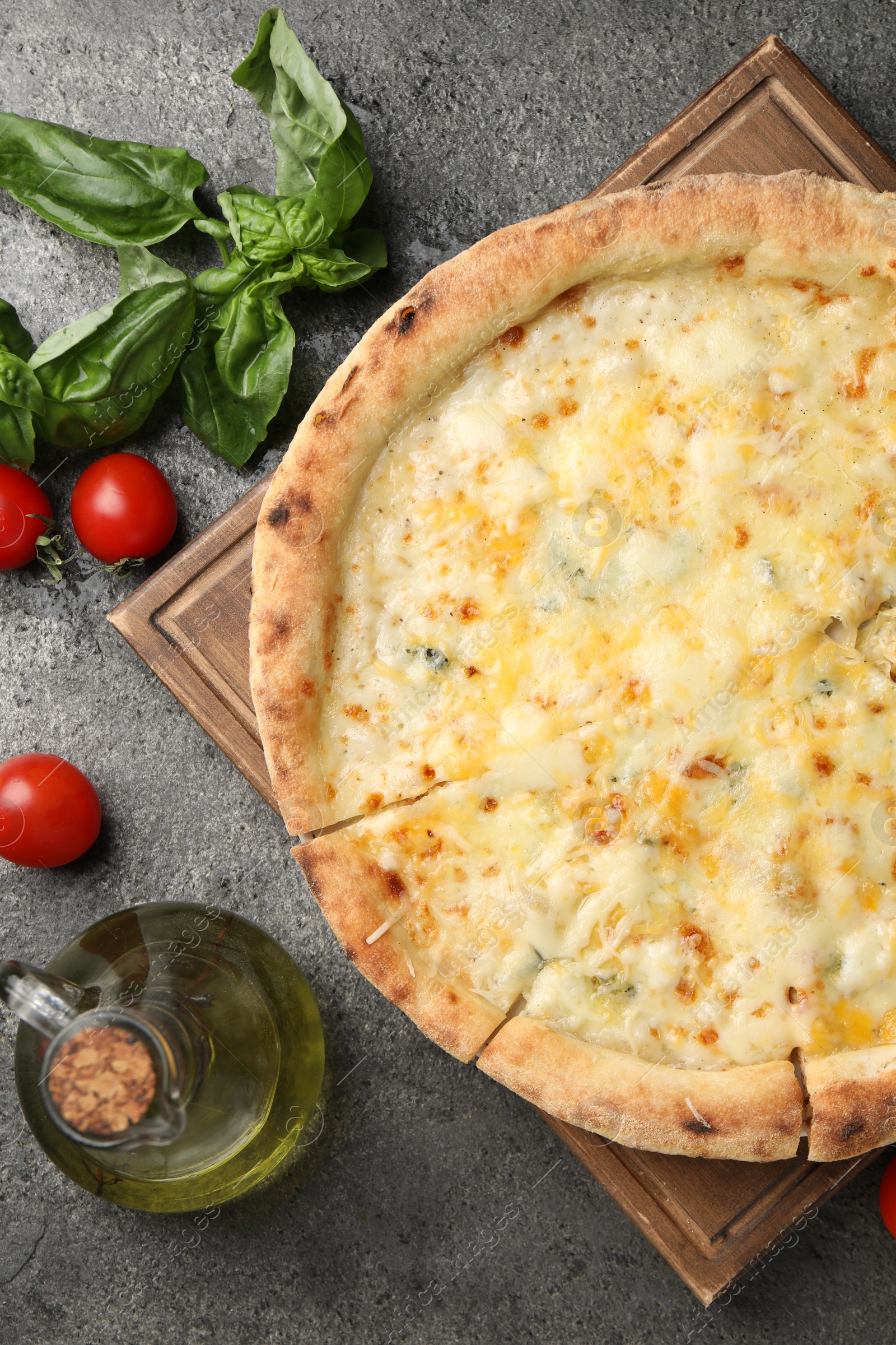 Photo of Delicious cheese pizza and ingredients on dark grey table, flat lay