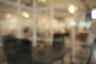 Photo of Blurred view of cozy workplace zone with table and chairs in office