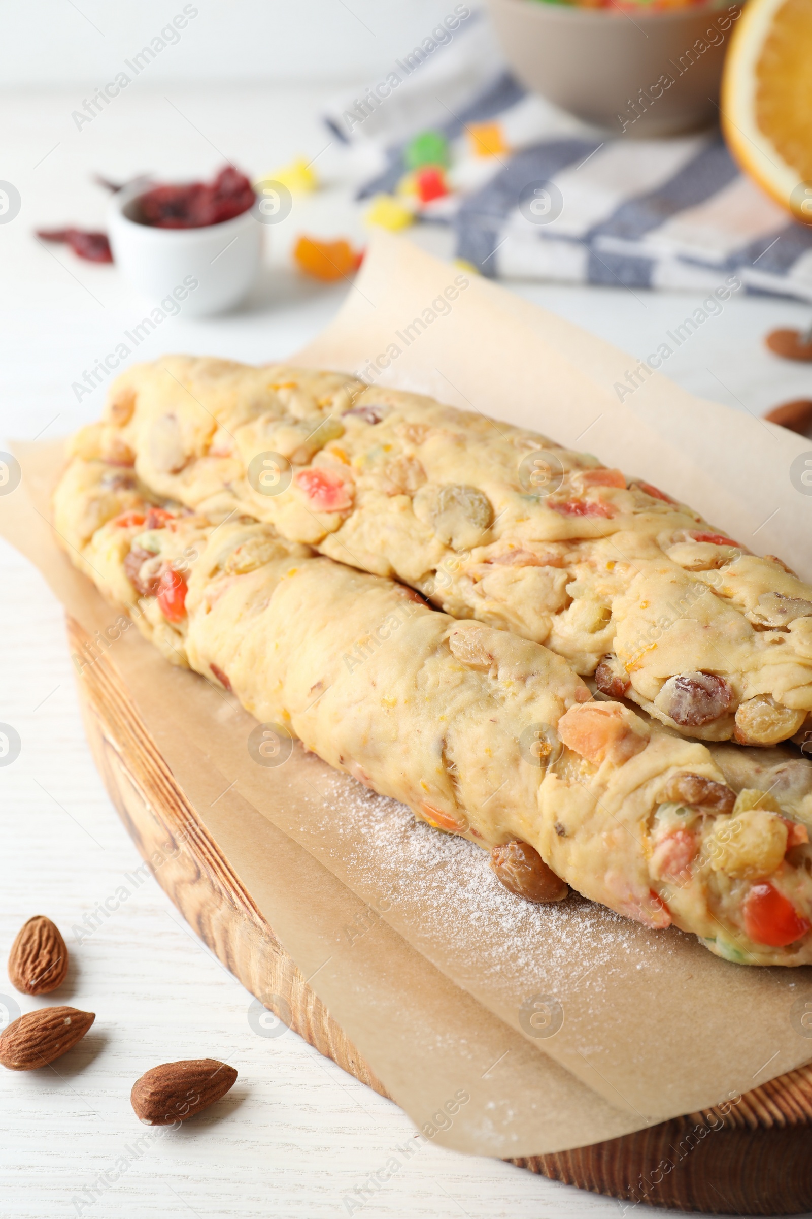 Photo of Unbaked Stollen with candied fruits and raisins on white wooden table