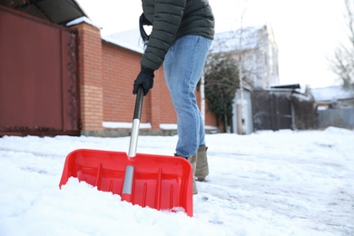 Photo of Person shoveling snow outdoors on winter day, closeup