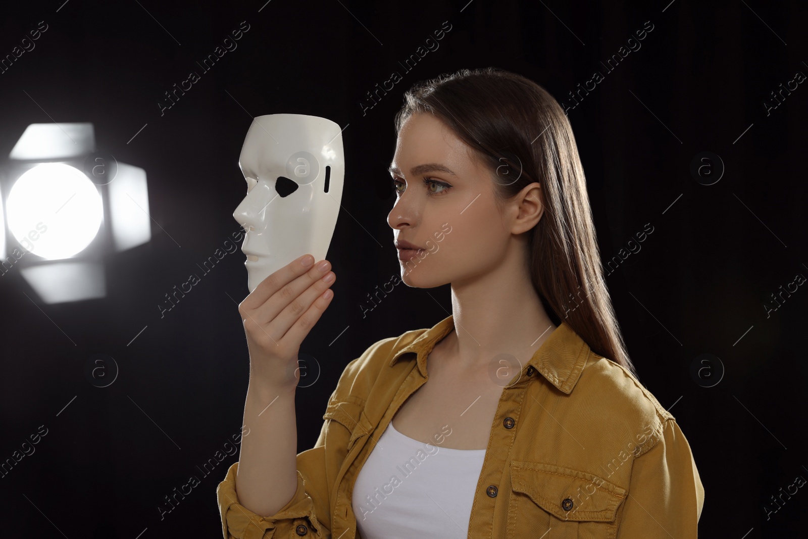 Photo of Professional actress rehearsing with mask on stage in theatre