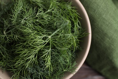 Bowl of fresh dill on table, top view