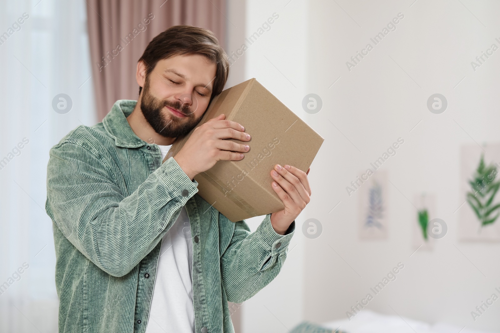 Photo of Man with parcel at home. Internet shopping