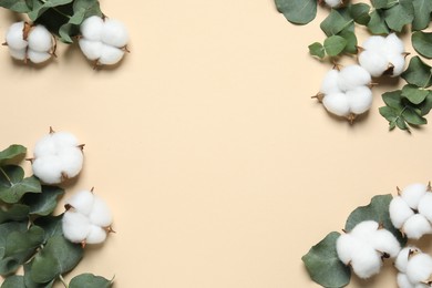 Photo of Cotton flowers and eucalyptus leaves on beige background, flat lay. Space for text