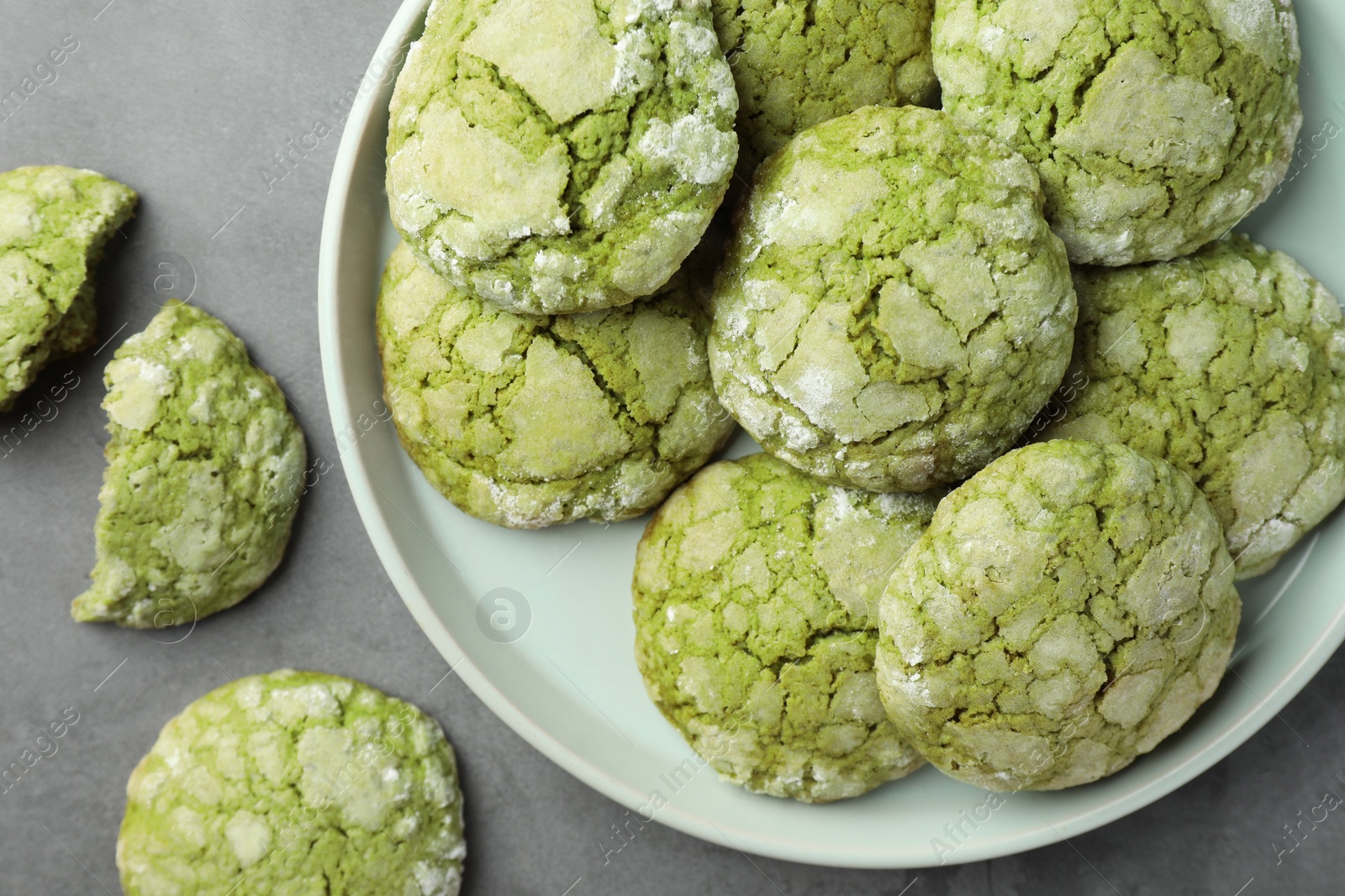 Photo of Plate with tasty matcha cookies on grey table, flat lay