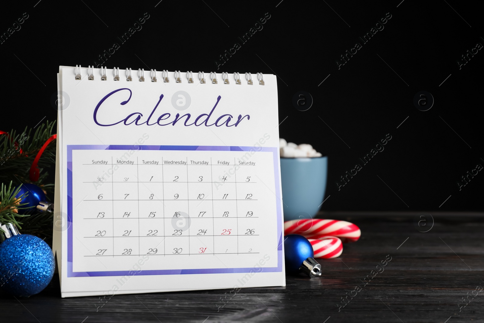 Photo of Flip calendar and Christmas decor on black wooden table. Holiday countdown