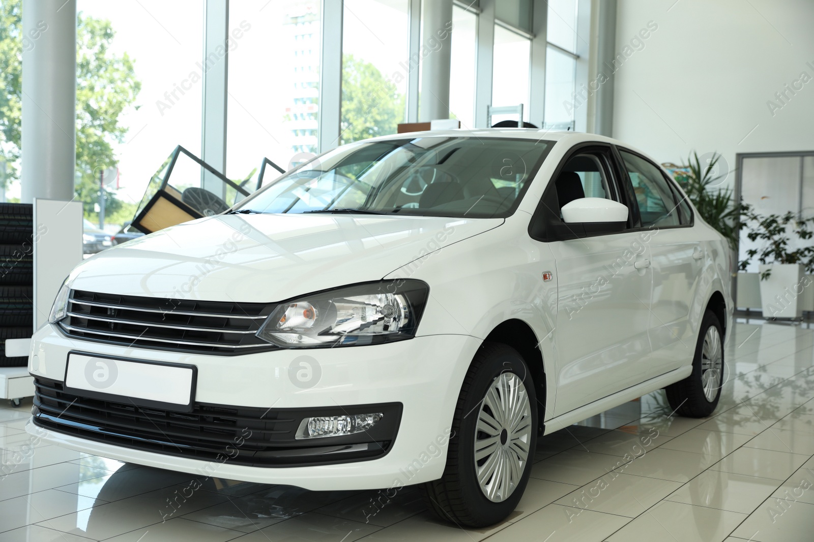 Photo of New luxury white car in modern auto dealership