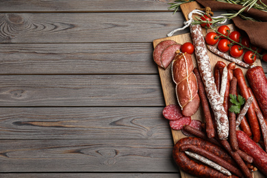 Photo of Different tasty sausages on wooden table, top view. Space for text