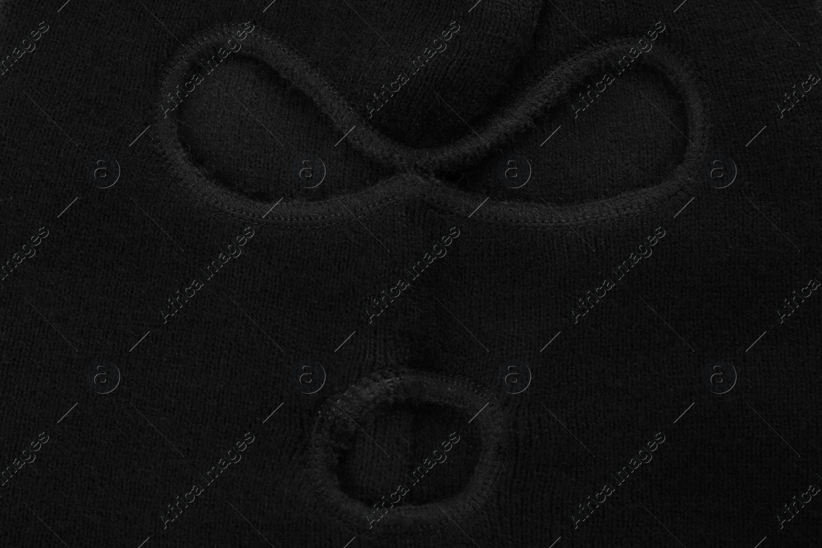 Photo of Black knitted balaclava as background, closeup view