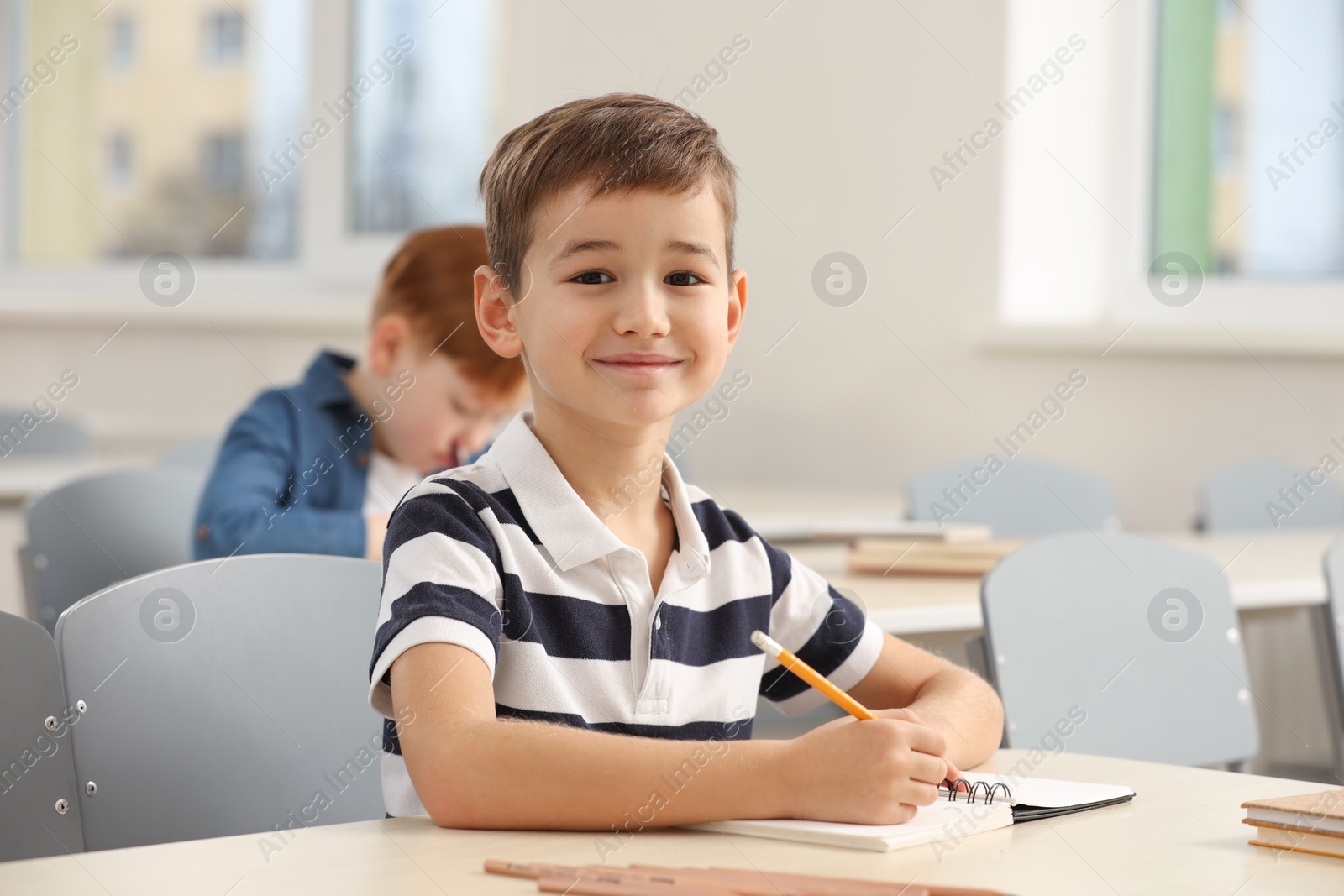 Photo of Portrait of cute little boy studying in classroom at school