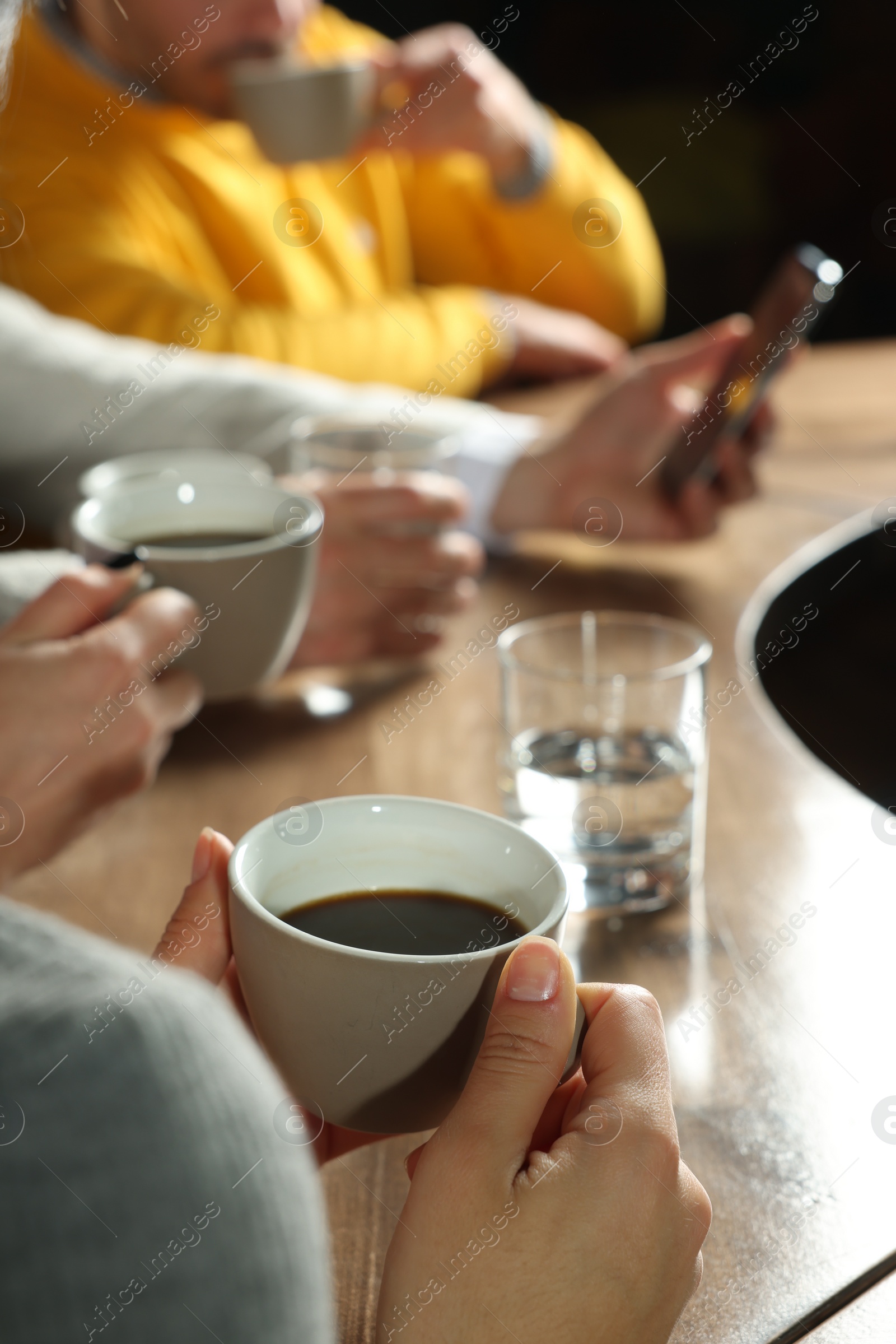 Photo of Friends with coffee spending time together in cafe, closeup