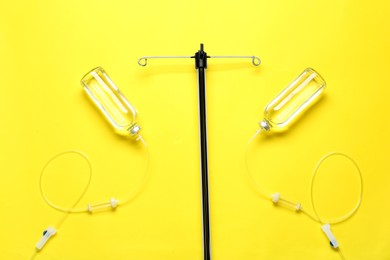 Photo of IV infusion set on yellow background, flat lay