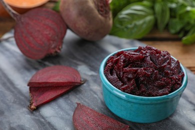 Photo of Bowl with tasty beet puree and ingredients on wooden table