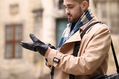 Photo of Handsome man in warm scarf on city street