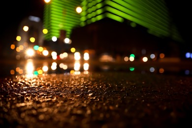 Photo of View of cityscape with bokeh effect, focus on asphalt. Night life