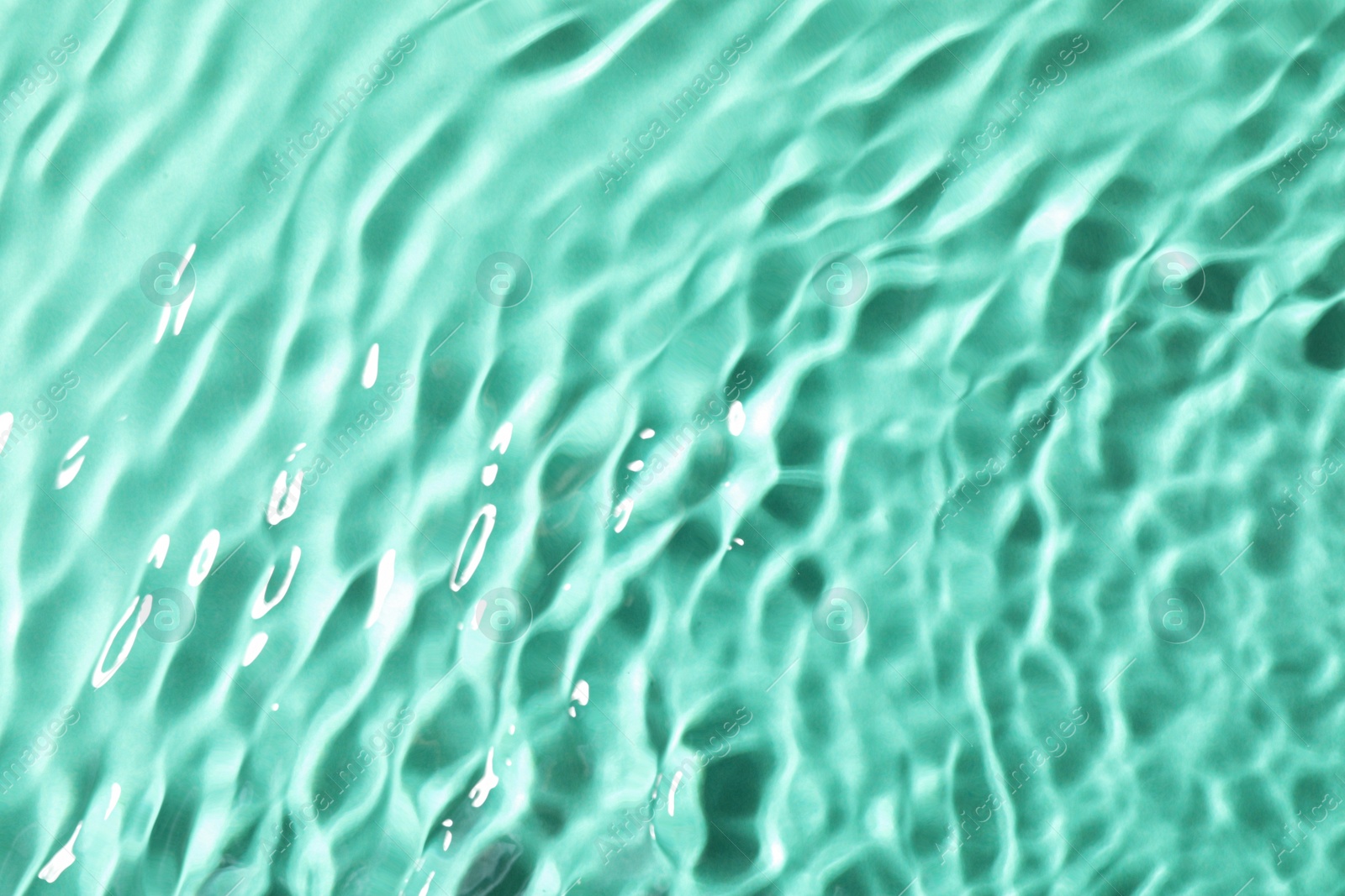 Photo of Closeup view of water with rippled surface on light blue background