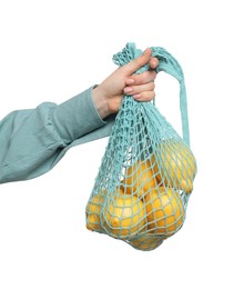 Woman with string bag of fresh lemons on white background, closeup