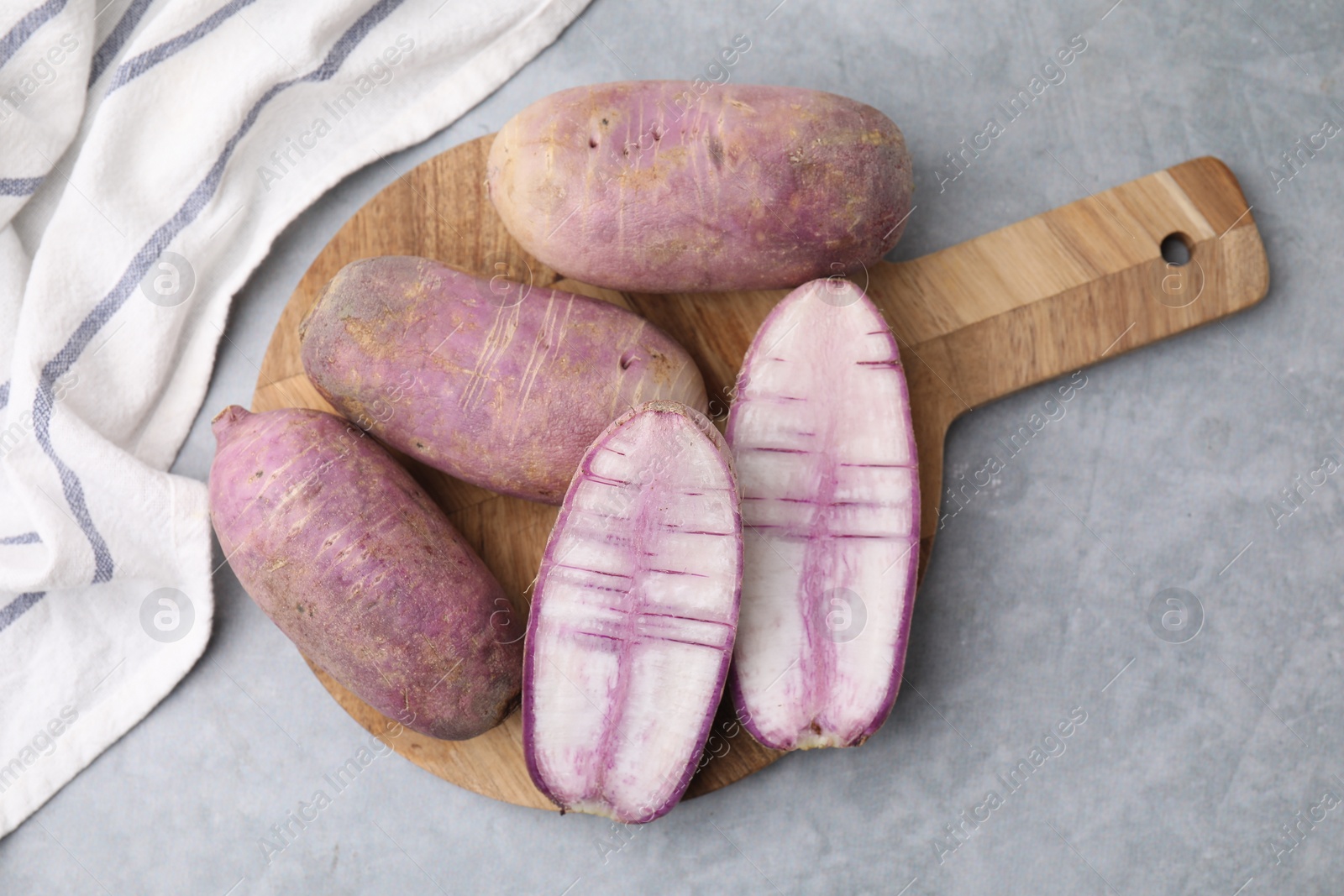 Photo of Purple daikon radishes on light grey table, top view