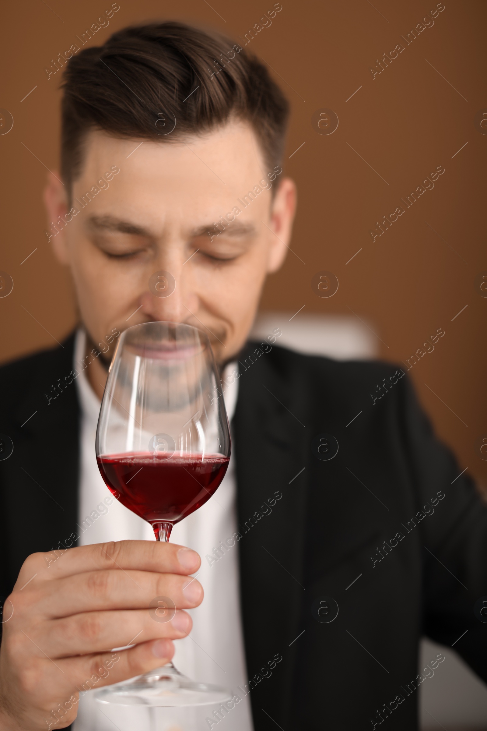 Photo of Young man with glass of wine indoors