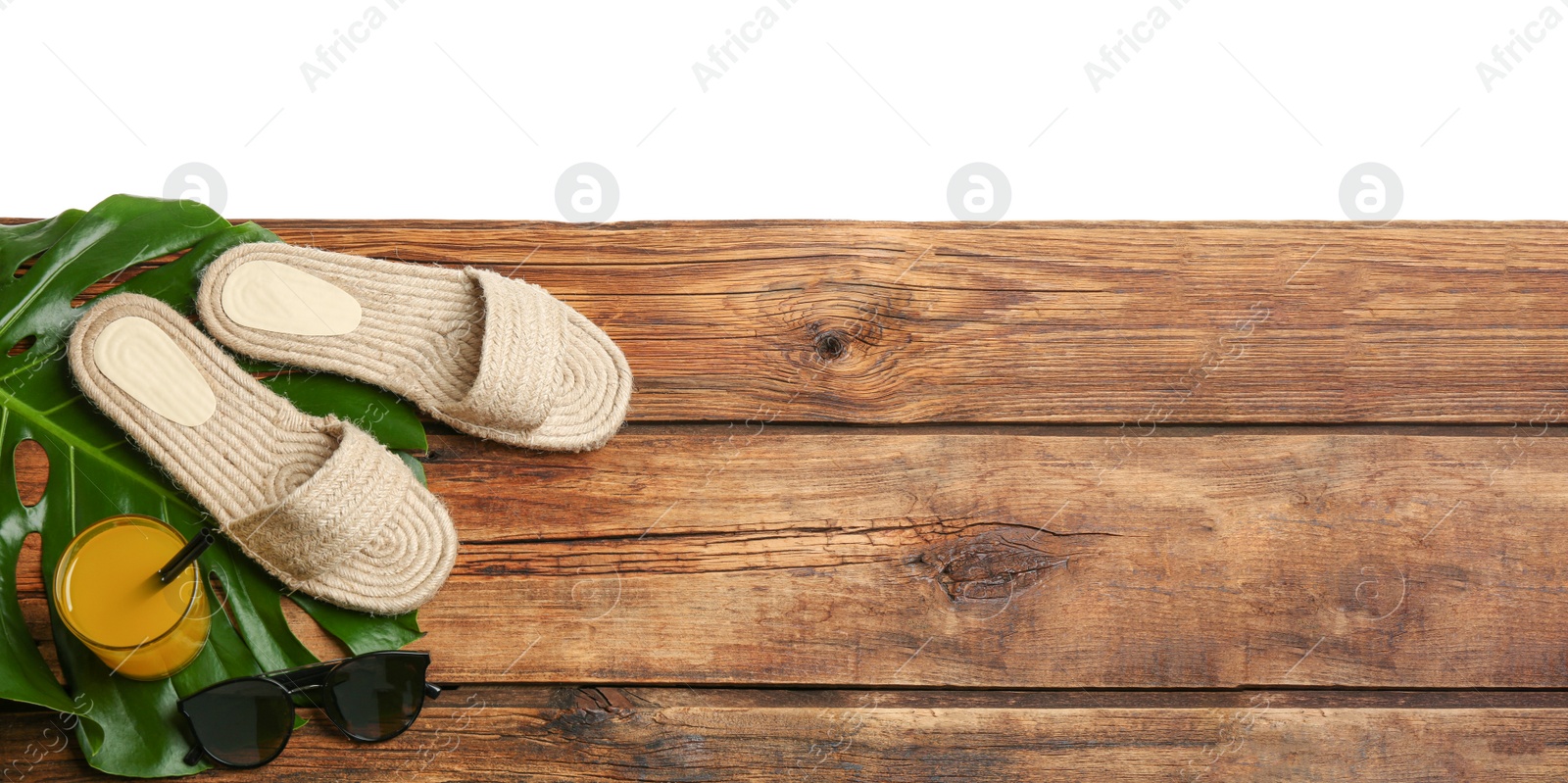 Photo of Beach accessories and drink on wooden table, flat lay. Space for text