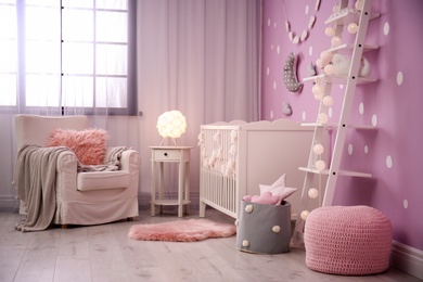 Baby room interior with crib near color wall