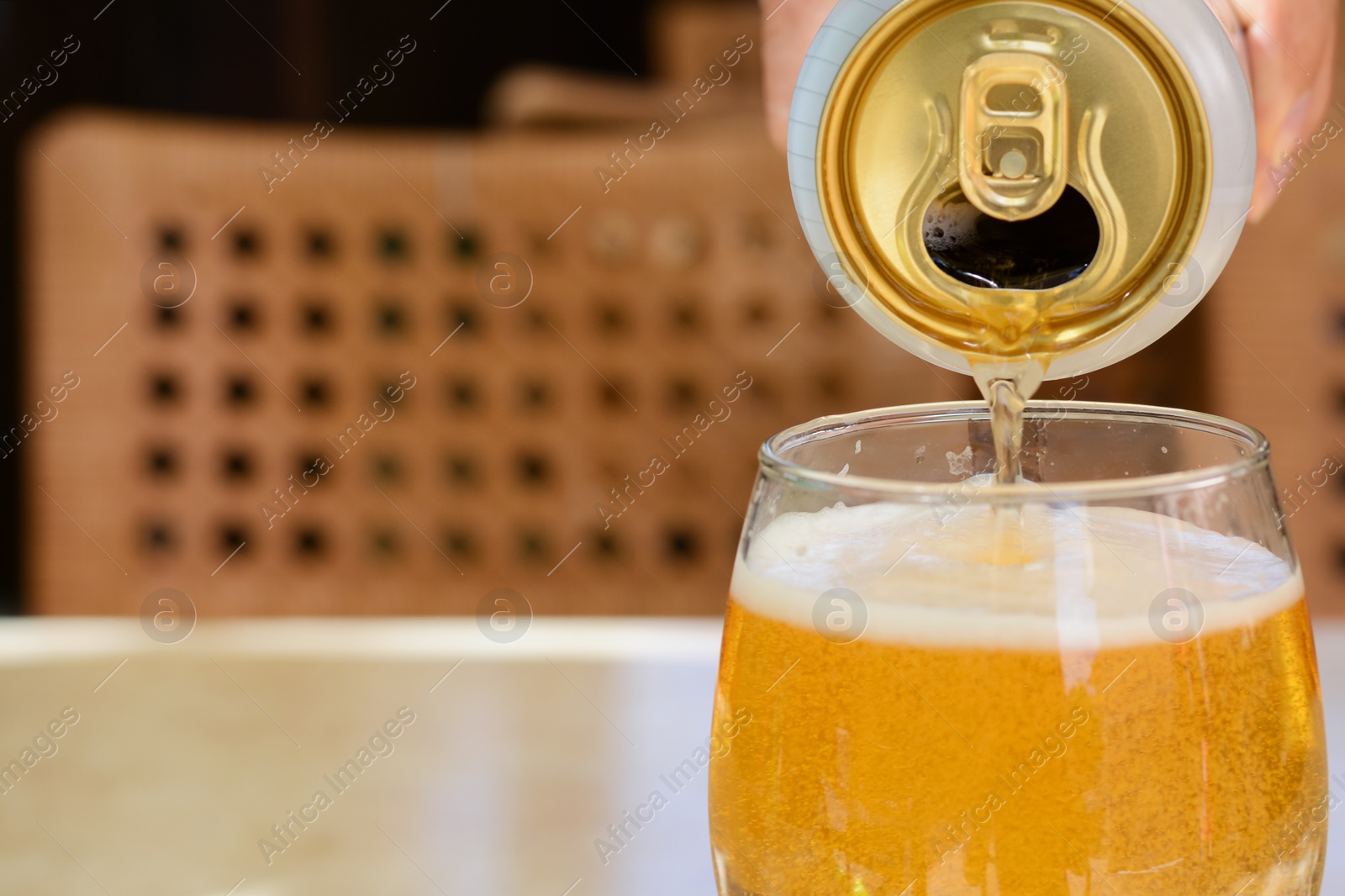 Photo of Man pouring beer from can into glass at table, closeup. Space for text