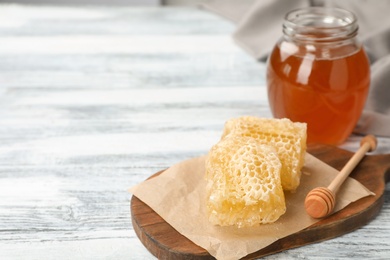 Photo of Composition with tasty fresh honeycombs and dipper on wooden board