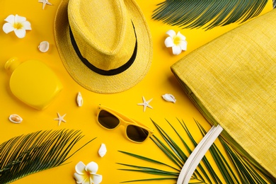 Flat lay composition with sunglasses and beach accessories on yellow background