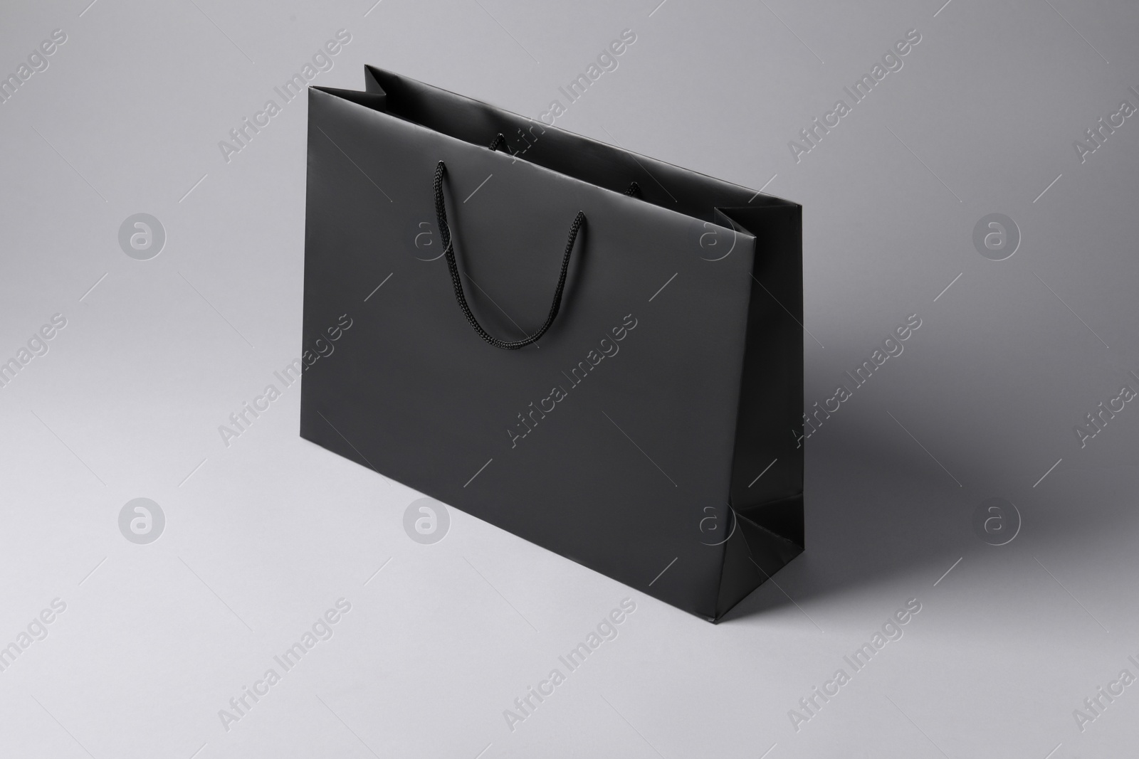 Photo of Black paper bag on light grey background