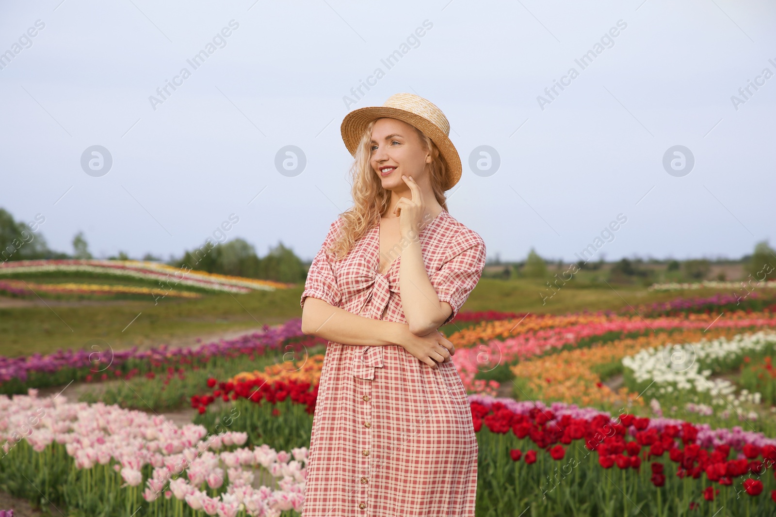 Photo of Happy woman in beautiful tulip field outdoors