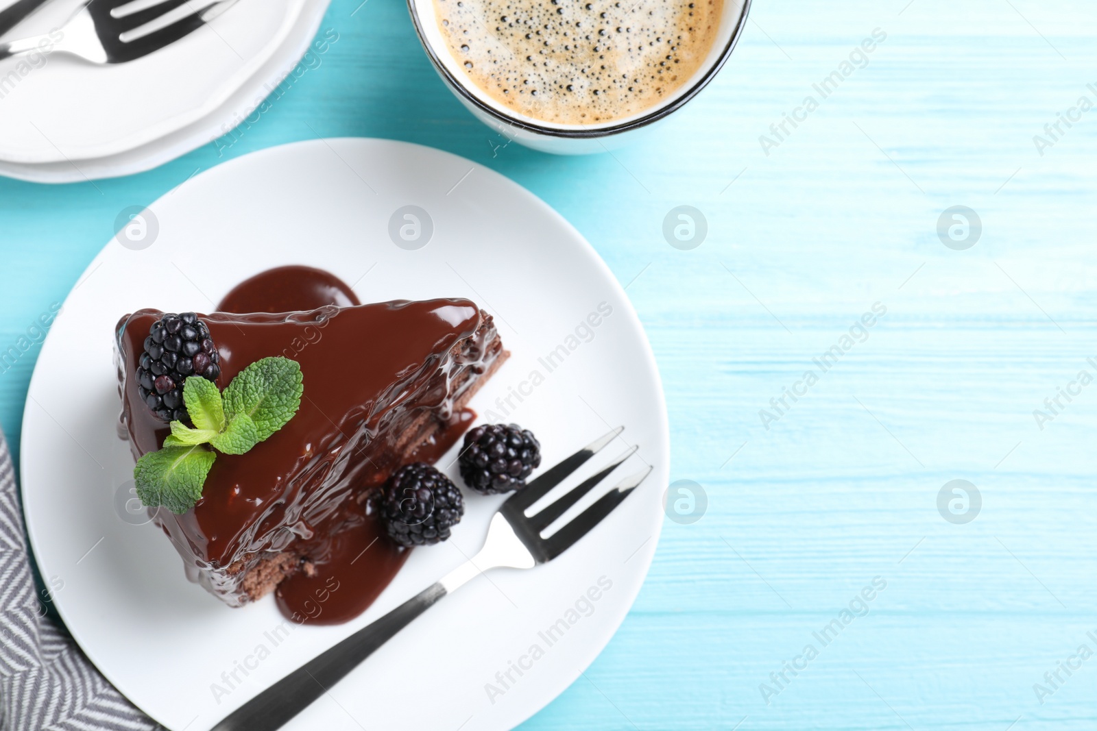 Photo of Delicious chocolate cake with blackberries on light blue wooden table, flat lay. Space for text