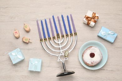 Flat lay composition with Hanukkah menorah and gift boxes on light wooden table