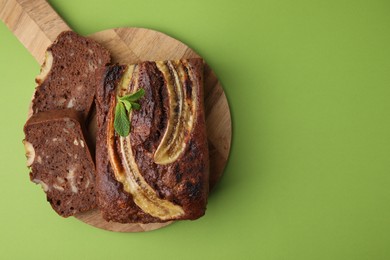 Delicious banana bread with mint on green background, top view