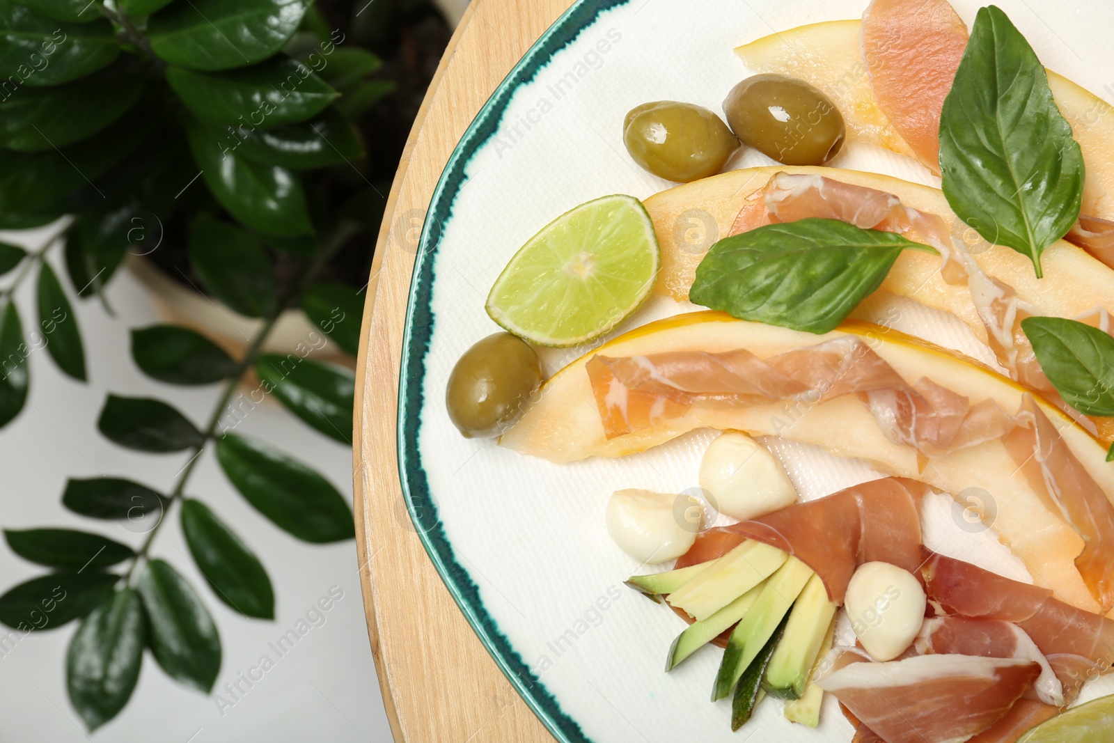 Photo of Plate with melon and prosciutto appetizer on table, top view