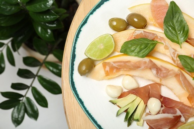 Photo of Plate with melon and prosciutto appetizer on table, top view