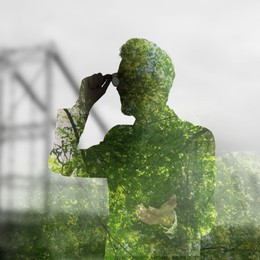 Double exposure of businessman and green trees in city