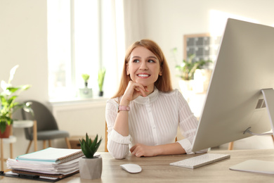 Photo of Young woman relaxing at table in office during break