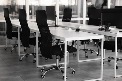 Photo of Comfortable office chairs and tables in meeting room