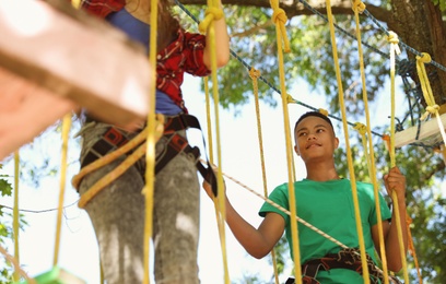 Photo of Children climbing in adventure park. Summer camp
