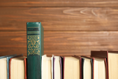 Photo of Collection of old books on wooden background, space for text