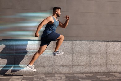 Sporty young man running on street. Light trails showing his speed