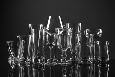 Empty glasses for different drinks on dark background