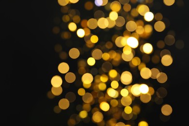 Blurred view of golden lights on black background. Bokeh effect