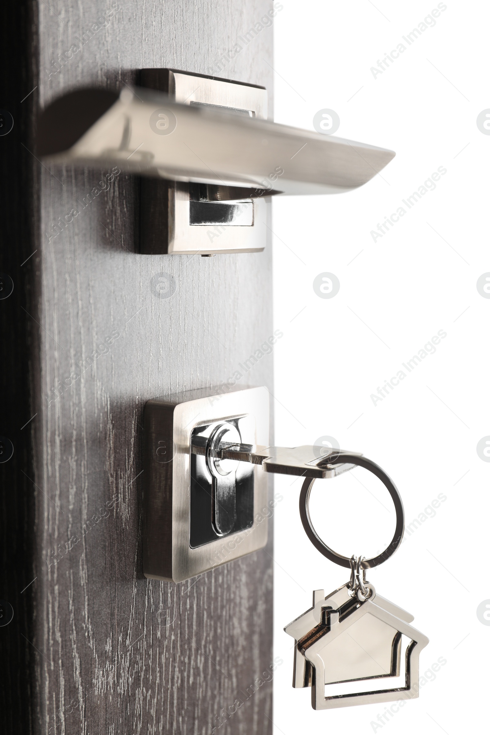 Photo of Mortgage and real estate. Open door with key and house shaped keychain on white background